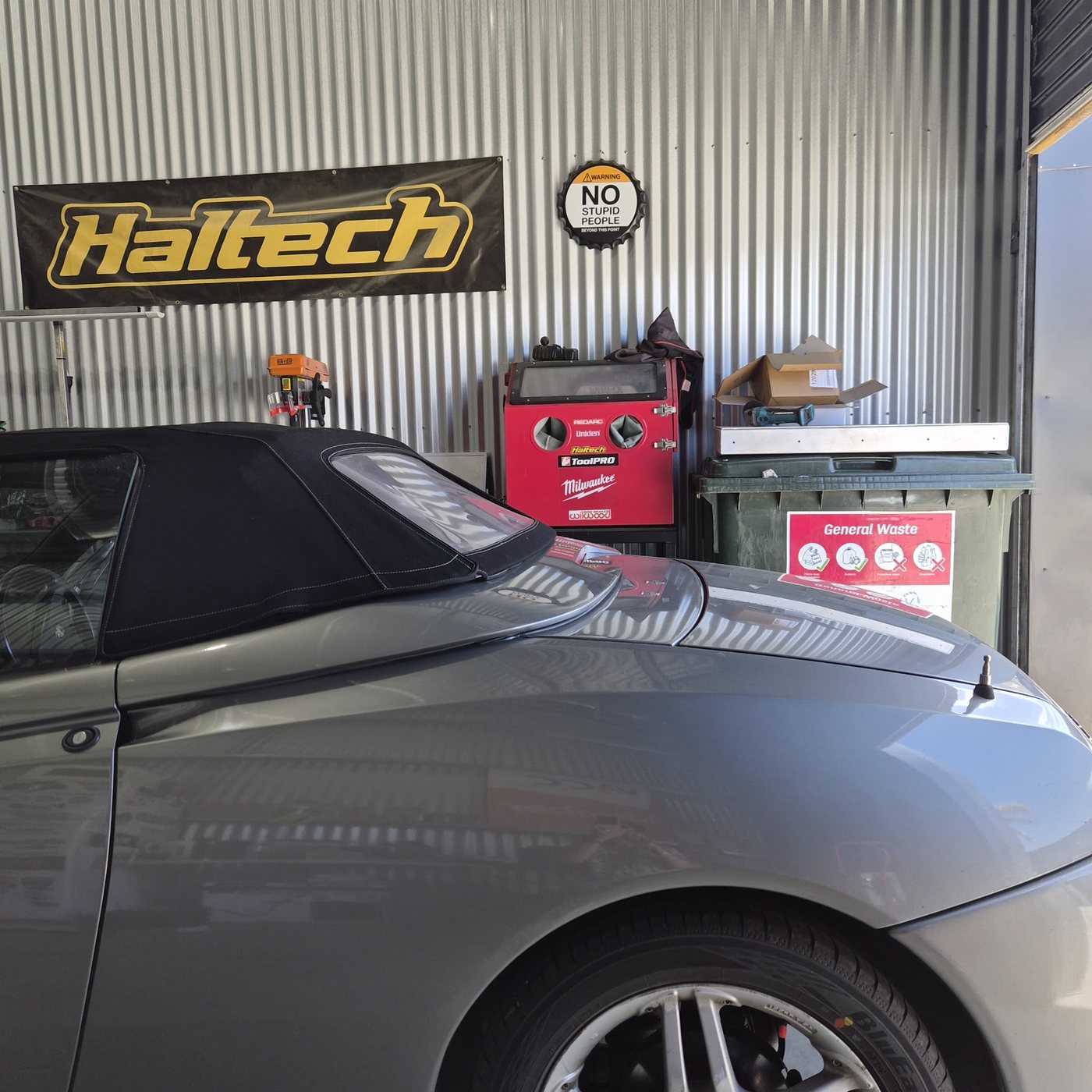 Inside the CRM shed: corrugated iron walls, a red tool cabinet and a workshop sign